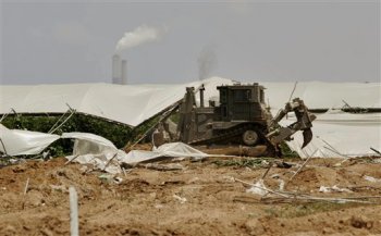 Un bulldozer destruye un invernadero palestino en el norte de Gaza. Foto: AP